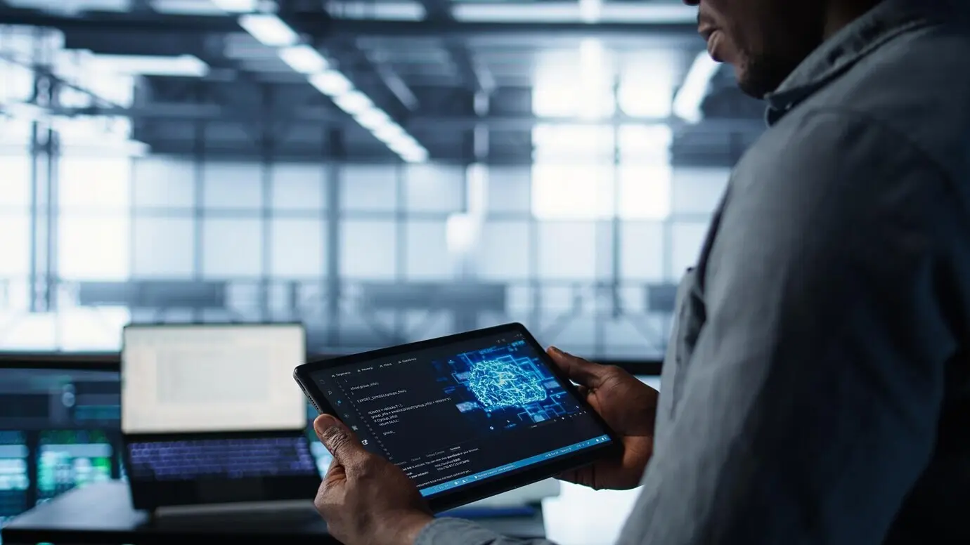 Крупный план специалиста по компьютерным наукам в центре обработки данных, который использует ИИ на планшете.